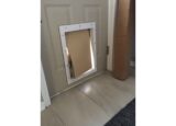Small dog pushing head through dog door